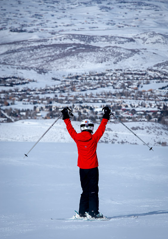 a skier in Colorado with her hands lifted above her head