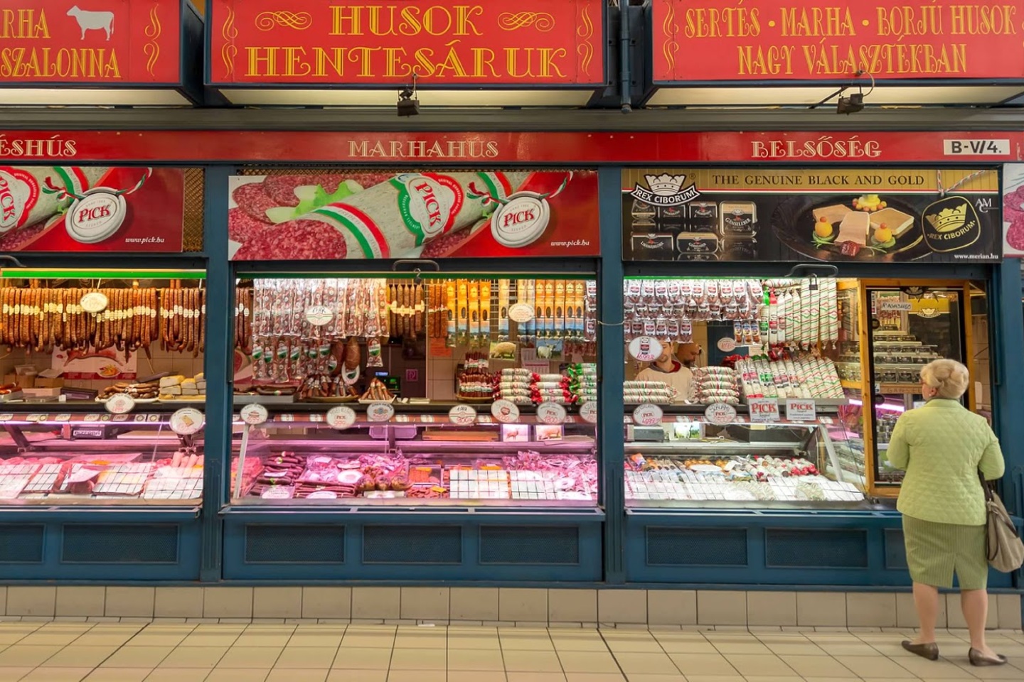 Photo of a deli storefront with a person looking at the options.