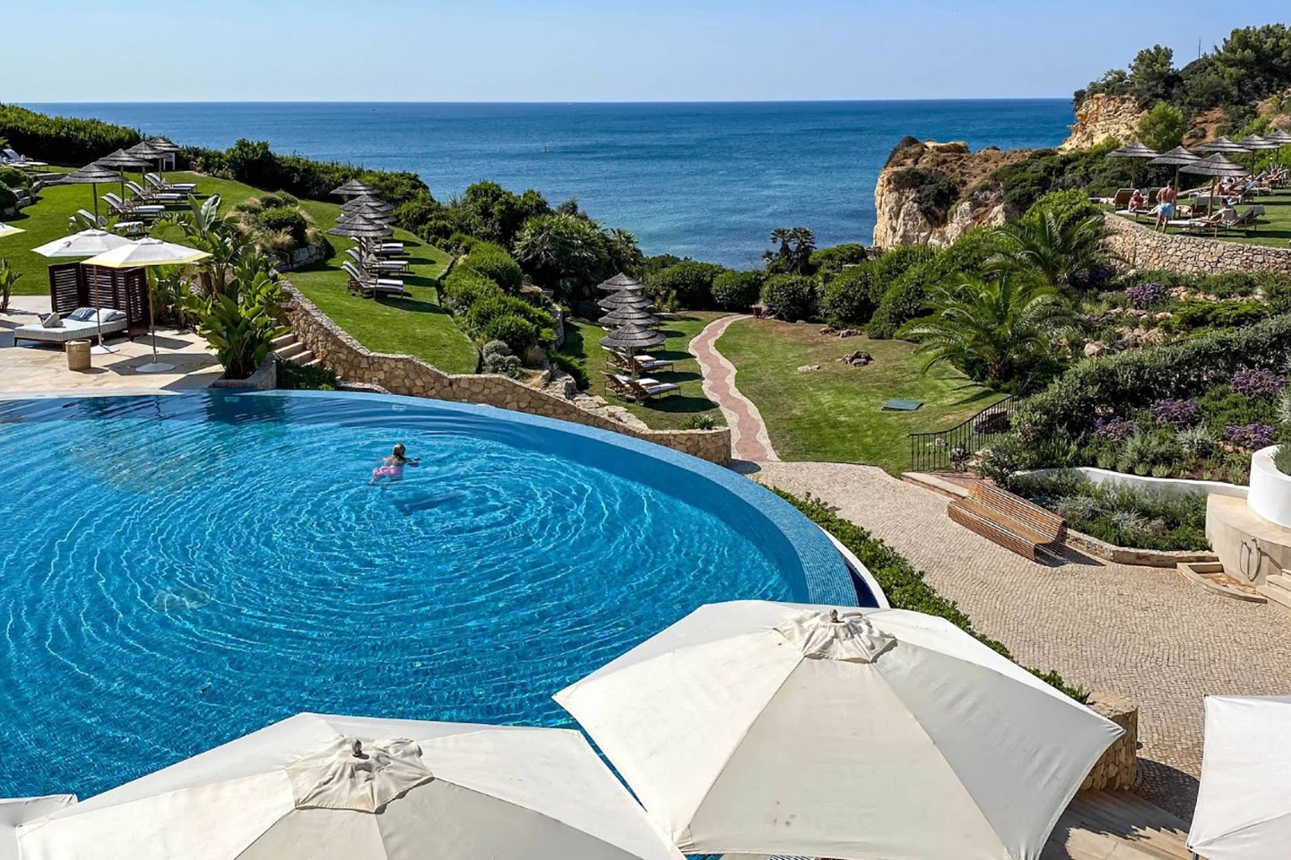 Photo of a coastal resort infinity pool with a lone swimmer in it