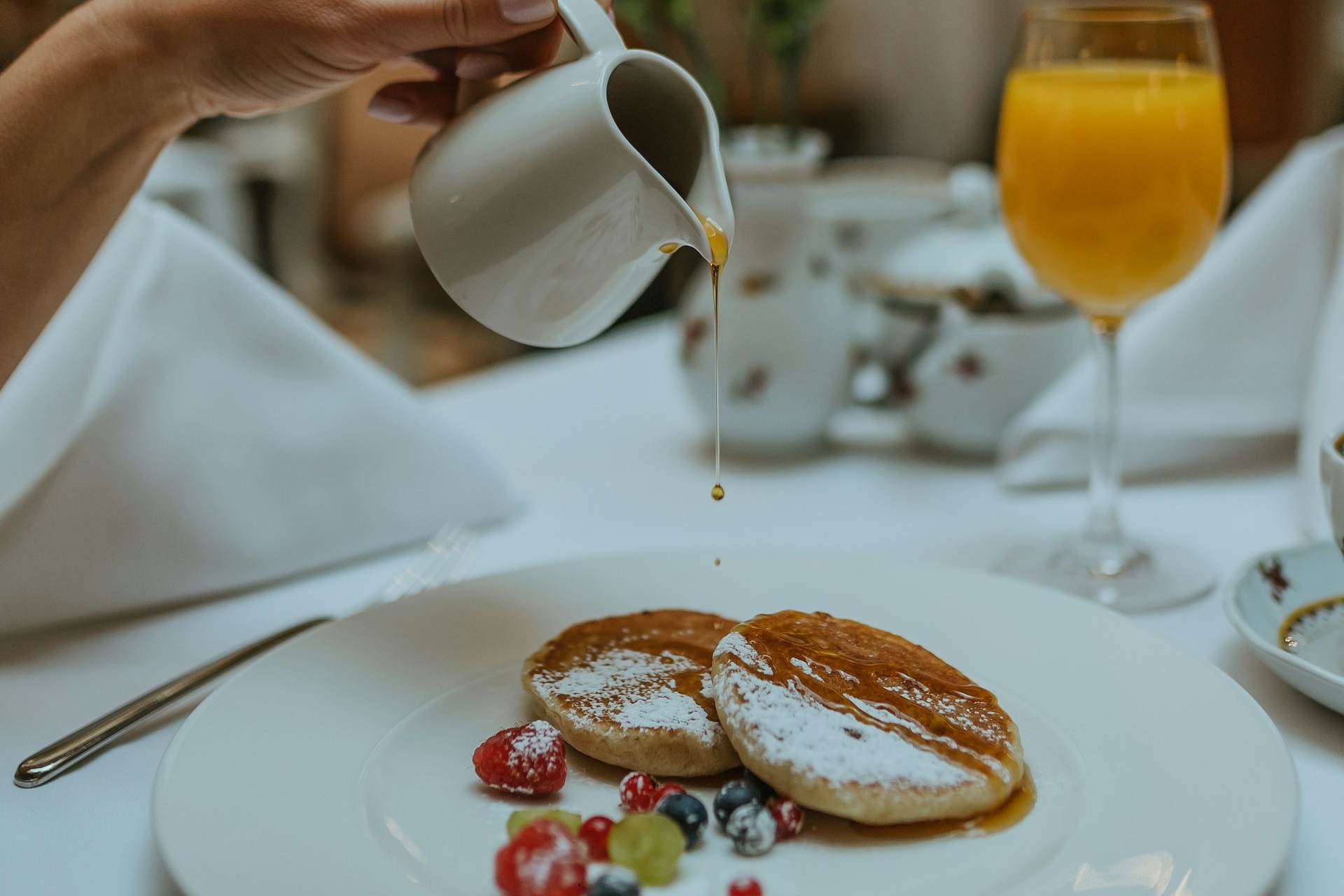 Photo of syrup being poured on pancakes