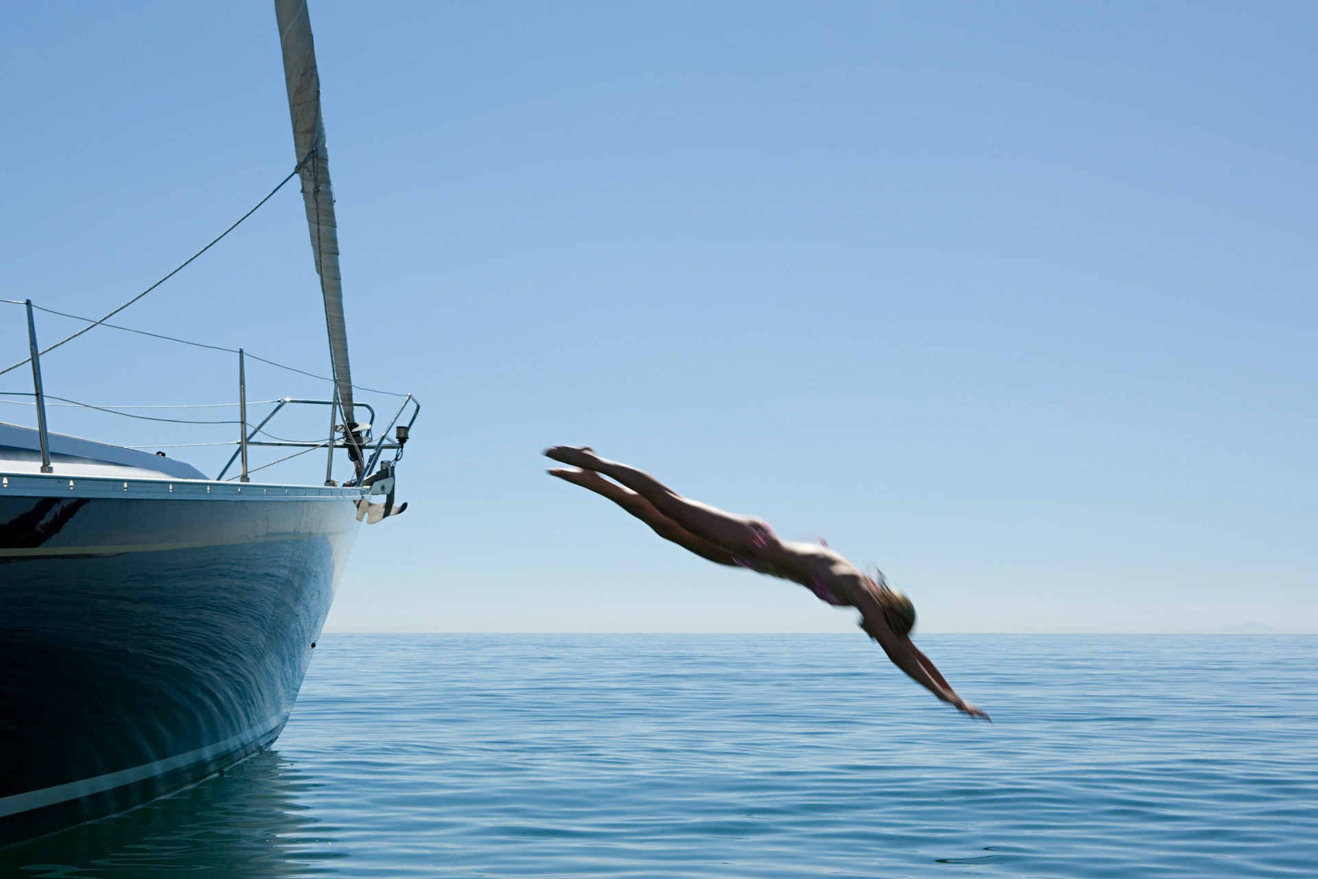 getty-images-7C0QX45Pt8Q-unsplash Photo of a person diving off the side of a boat.
